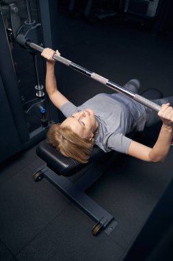 Spor yaparken halter çekme makinesi kullanan bir kadın.