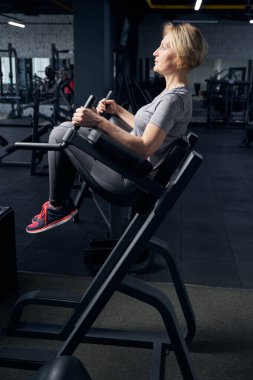 Spor salonunda spor malzemesi kullanan bir kadın.