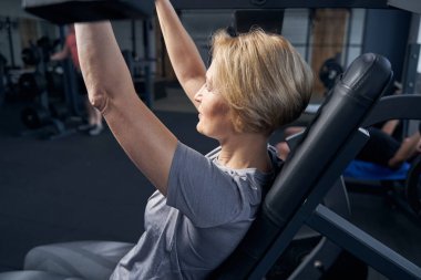 Sarışın kadın spor salonunda çalışıyor.