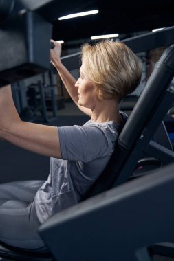 Sarışın kadın spor salonunda egzersiz yapıyor.