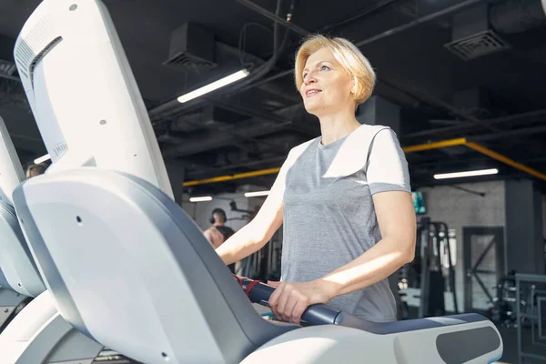 Mujer alegre haciendo ejercicio cardiovascular en el gimnasio —  Fotos de Stock