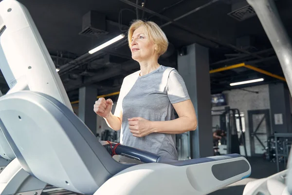 Mujer deportiva activa haciendo ejercicio cardiovascular en el gimnasio —  Fotos de Stock