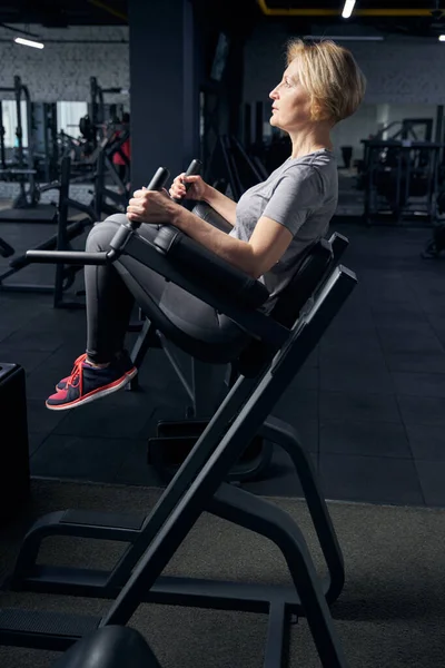 Mujer deportiva que utiliza equipos de fitness en el gimnasio — Foto de Stock