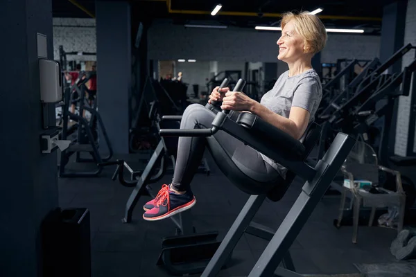 Mujer alegre usando equipo de fitness en el gimnasio — Foto de Stock