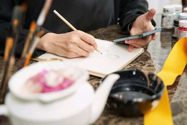 Diseñadora musulmana creando vestidos en cuaderno de bocetos — Foto de Stock