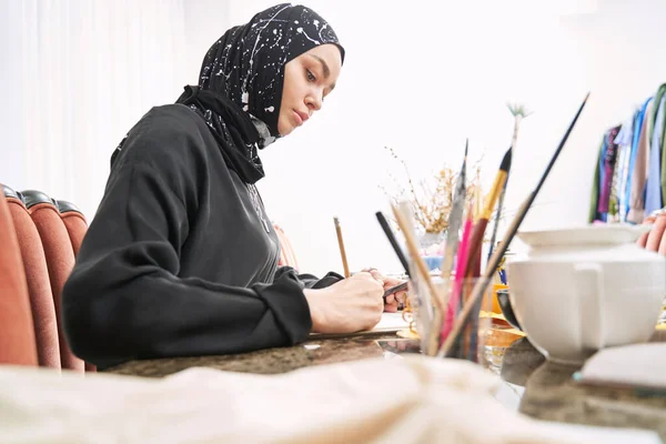 Créatrice musulmane créant des vêtements dans un carnet de croquis — Photo