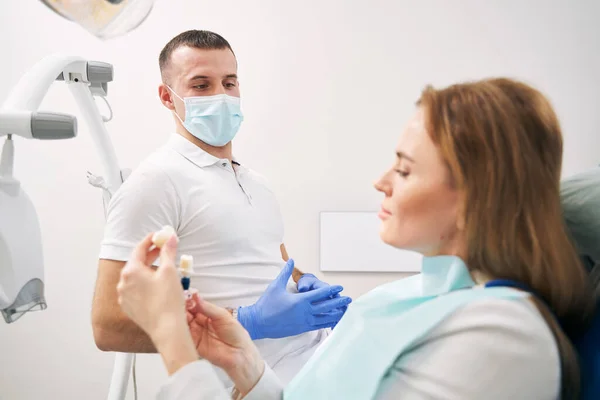 Zahnarzt bespricht Zahnbehandlung mit Frau in Klinik — Stockfoto