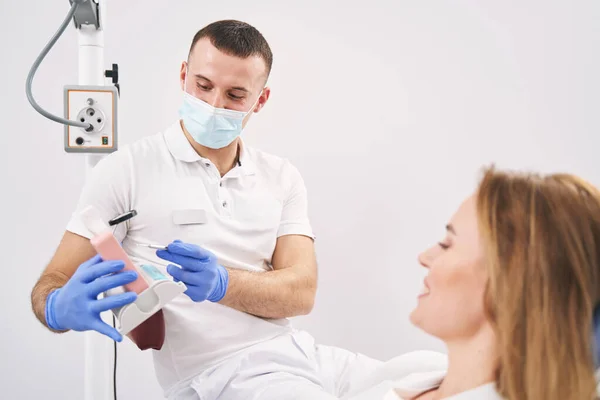Dişçi, dişçi kliniğindeki kadına diş modelini gösteriyor. — Stok fotoğraf