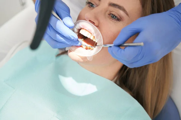 Vrouw met cofferdam in mond met tandheelkundig onderzoek in kliniek — Stockfoto