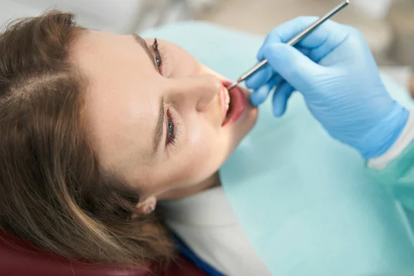 Dentiste vérifiant les dents de la femme avec miroir dentaire — Photo