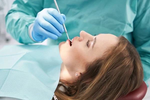 Dokter onderzoeken vrouw tanden met tandheelkundige spiegel — Stockfoto