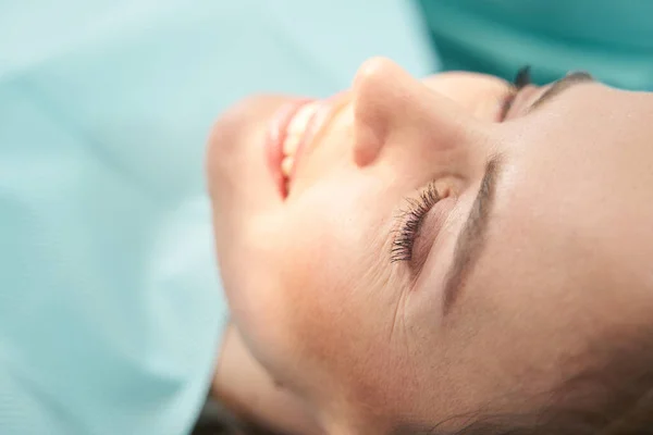 Glädjande kvinna vilar efter ingreppet i stomatologiska kliniken — Stockfoto