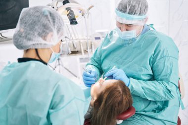 Stomatoloji kliniğinde diş tedavisi gören kadın.