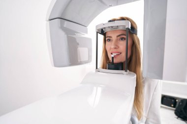 Stomatoloji kliniğinde dişçi ekipmanı kullanan bir kadın.