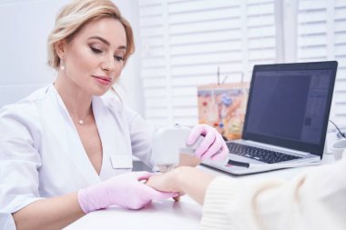 Profesyonel dermatolog hasta üzerinde kozmetik işlem yapıyor.