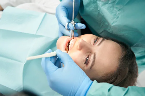 Mujer que recibe tratamiento dental en consultorio odontológico — Foto de Stock