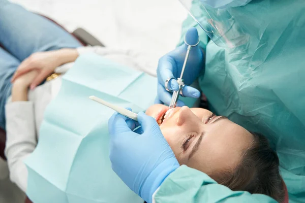 Vrouwelijke patiënt die tandheelkundige behandeling krijgt in een stomatologiekliniek — Stockfoto