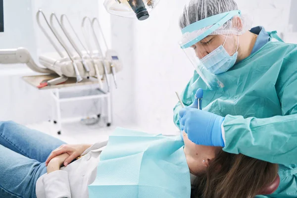 Dentysta wykonujący leczenie stomatologiczne w klinice stomatologicznej — Zdjęcie stockowe