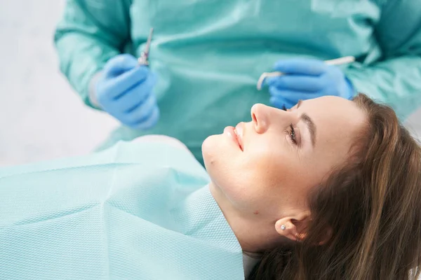 Stomatoloji kliniğinde dişçi koltuğunda yatan kadın. — Stok fotoğraf