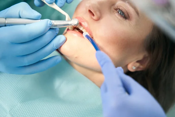 Dentista realizando procedimento odontológico com broca dentária — Fotografia de Stock