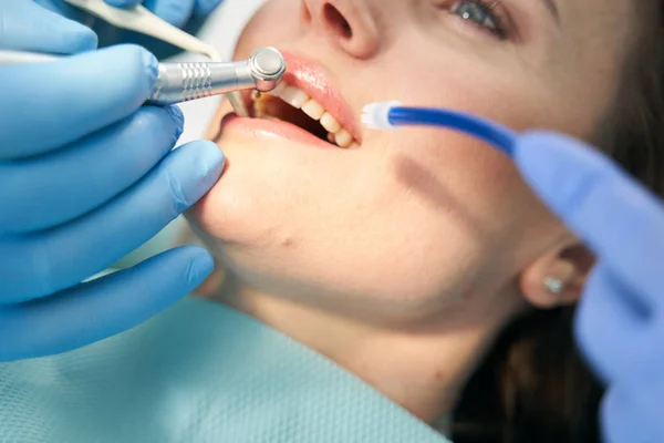 Dentista realizando procedimiento de tratamiento de dientes con taladro dental — Foto de Stock