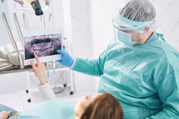 Dentista mostrando exploración dental a mujer en clínica de estomatología — Foto de Stock