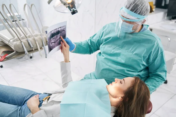 Mujer discutiendo exploración dental con médico en clínica de estomatología —  Fotos de Stock