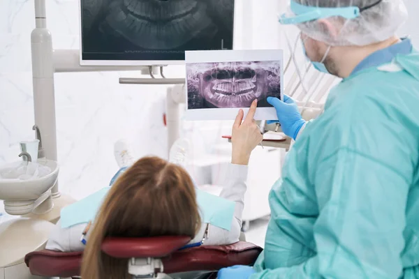 Vrouw bespreekt tandheelkundige röntgenfoto met tandarts in stomatologie kliniek — Stockfoto