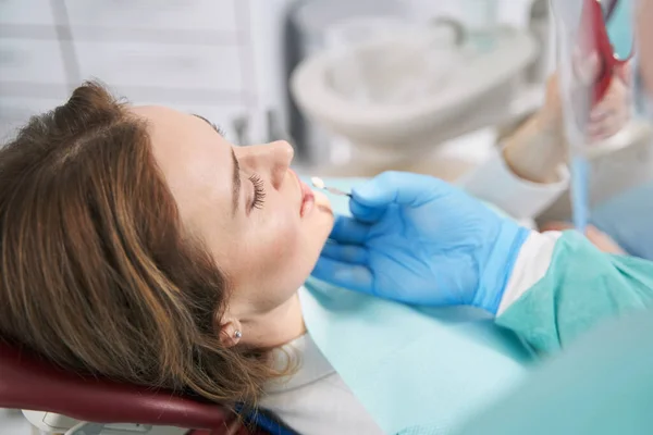 여자 치아의 색깔을 치과용 이식편 과 비교하는 의사 — 스톡 사진