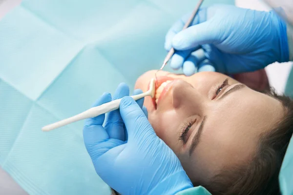 Fogorvos női fogakat vizsgál a fogászati klinikán — Stock Fotó