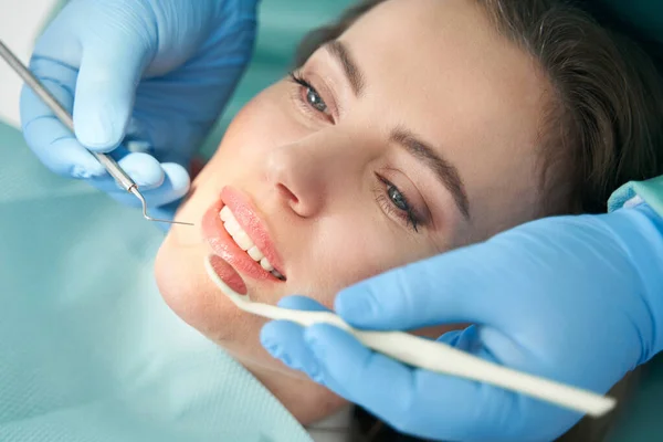 Fogorvos női fogakat vizsgál a fogászati klinikán — Stock Fotó
