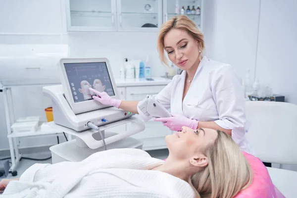 Dermatólogo ajustando el ajuste del tratamiento para el paciente antes del procedimiento cosmético — Foto de Stock