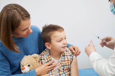 Çocuk pediatri kliniğinde aşı yaptırıyor.