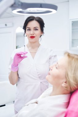 Modern güzellik kliniğinde çalışan güzel bir kozmetikçi.