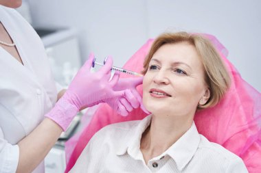 Güzellik kliniğinde bulunan mutlu bir hastanın portresi.