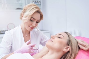 Aksiller hiperhidroz için hastayı tedavi eden deneyimli bir cildiyeci.