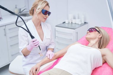 Dermatolog lazer terapi seansından önce müşteriyi rahatlatıyor