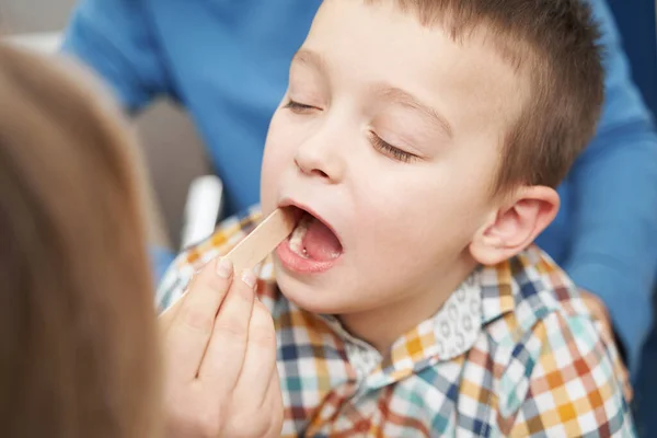 Arzt untersucht Kinderkehle mit Zungendepressor — Stockfoto