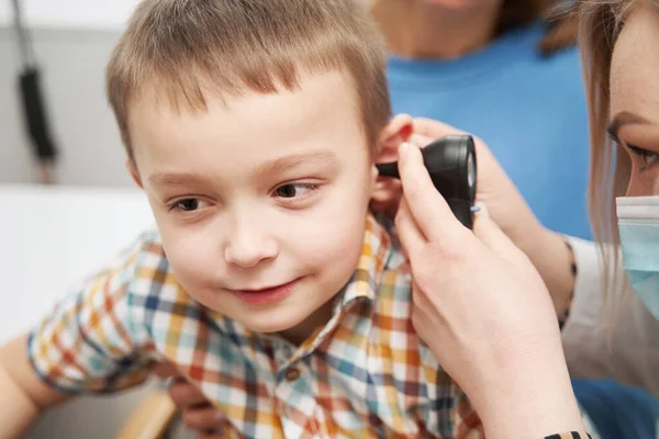 Médecin examinant petite oreille de garçon avec otoscope à la clinique — Photo
