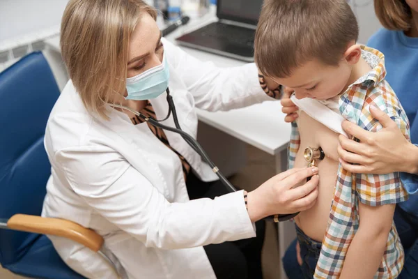 Médica examinando criança com estetoscópio na clínica — Fotografia de Stock