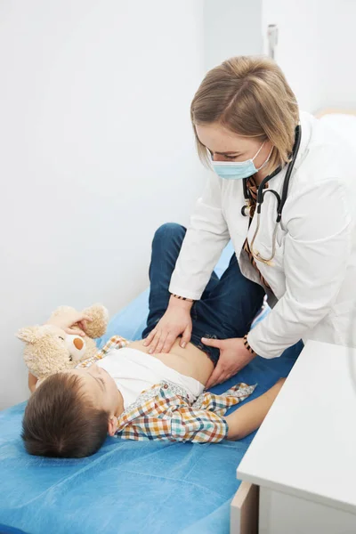 Medico donna che esamina addome infantile in clinica pediatrica — Foto Stock