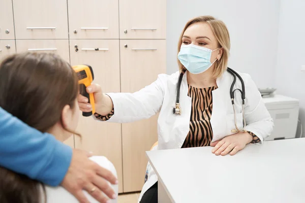 Γυναίκα γιατρός ελέγχει τη θερμοκρασία του παιδιού στην κλινική — Φωτογραφία Αρχείου