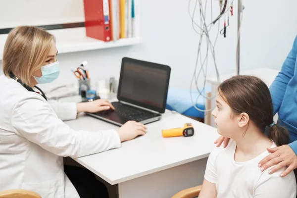 Female doctor talking with little girl in clinic — Stock Photo, Image