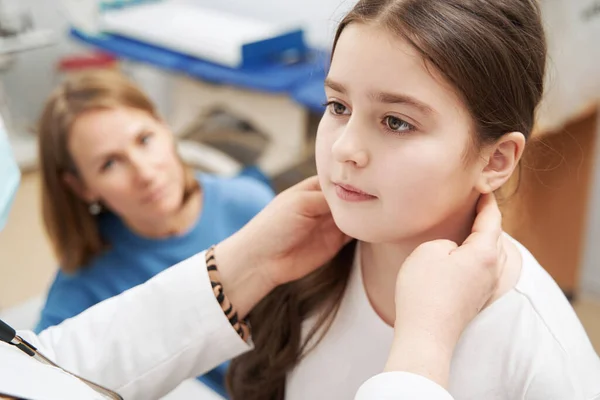 Vrouwelijke arts onderzoekt kind lymfeklieren in kliniek — Stockfoto