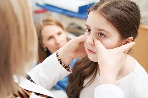 Médico feminino examinando menina na clínica — Fotografia de Stock