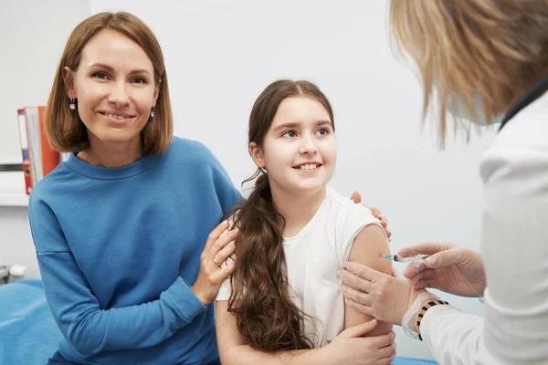 Smiling little girl getting vaccine injection in clinic — Stock Photo, Image