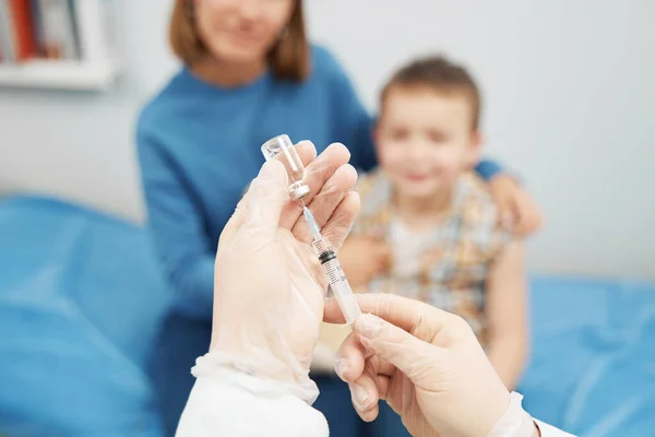 Доктор руки заповнює шприц розчином вакцини в клініці — стокове фото