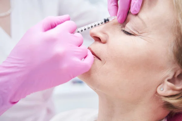Kompetenter Kosmetologe macht Injektion, um Falten zu füllen — Stockfoto