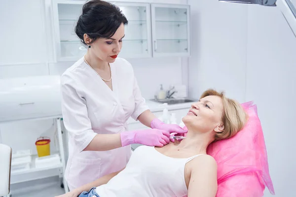 Mujer madura feliz visitando a su cosmetólogo profesional — Foto de Stock