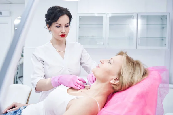 Young beauty master working with senior patient — Stock Photo, Image